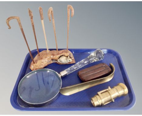 A tray containing large crystal magnifying glass, brass shoehorn, leather cigar case, miniature walking stick stand etc.