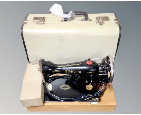 A vintage Singer electric sewing machine with lead and pedal in box.