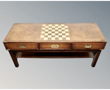 A rectangular low coffee table with chessboard top and brass drop handles. (width 120cm)