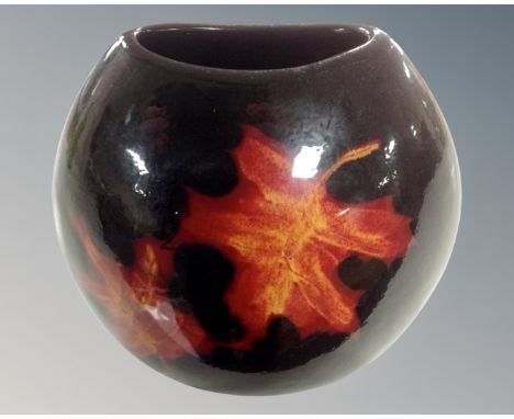 A Poole vase decorated with autumn leaves. (height 18cm)