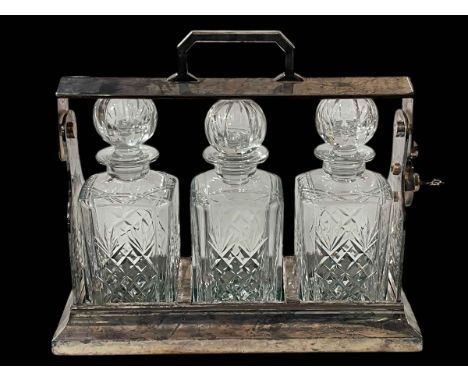 Silver plated three bottle tantalus.