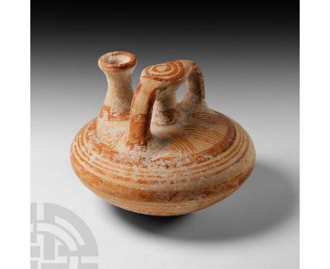 1400-1200 B.C. A pottery vessel formed with a squat carinated body, slender waisted neck and similar central stem with two fl