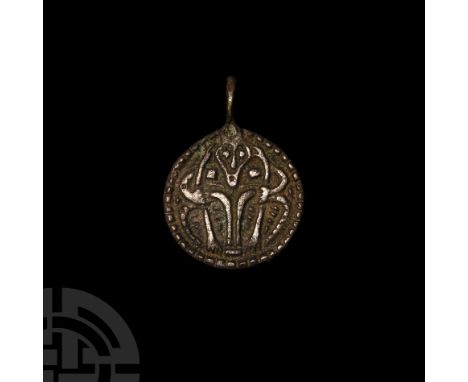 9th-10th century A.D. A discoid silver pendant with integral loop, beaded border enclosing a low-relief image of a male facin