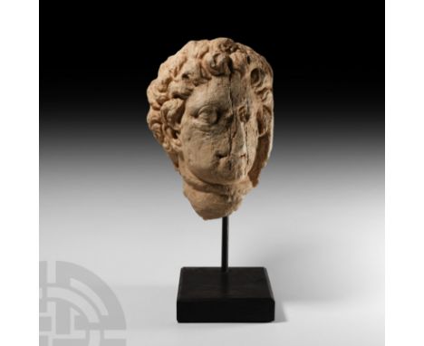 3rd-6th century A.D. A carved marble head with large lentoid eyes and wavy hair; mounted on a custom-made stand. Cf. similar 