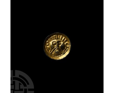 5th-8th century A.D. A superb chip-carved saucer or button brooch with extensive remains of gilding, displaying a stylised ma