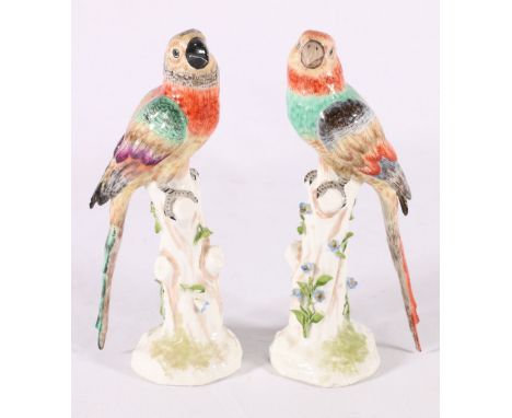 Pair of Meissen style continental porcelain bird models raised on naturalistic trunk bases with relief flowerhead and foliage