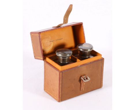 Pair of silver topped toilet bottles, in leather case initialled EC, London 1919, case 11.5cm tall.