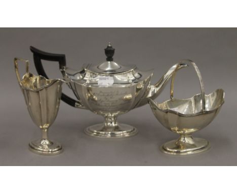 An associated three piece silver tea set, the teapot bearing description. 26.5 cm long. 684.2 grammes total weight.