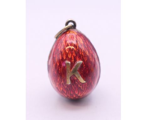 A red enamel egg form pendant. 2 cm high. 