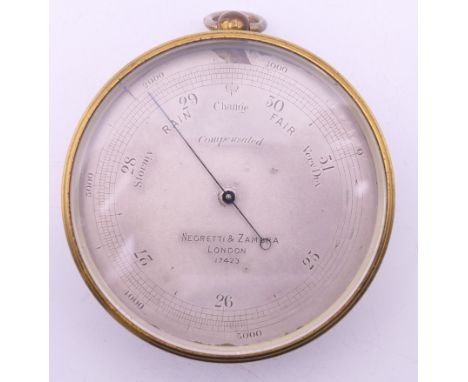 A Negretti &amp; Zambra of London brass barometer, in original case, numbered 17423. 7 cm diameter.