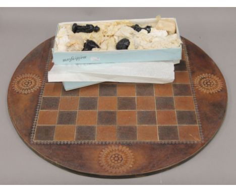 A vintage chess set and a leather covered chess board. The board 60 cm diameter. 