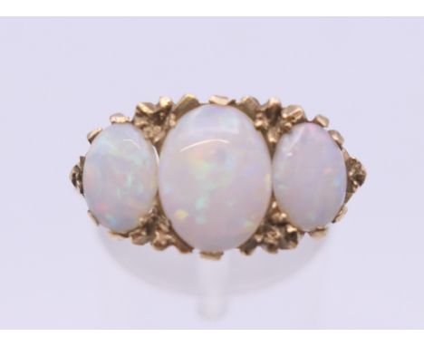 A 9 ct gold opal three stone ring. Ring size N/O. 4.6 grammes total weight.