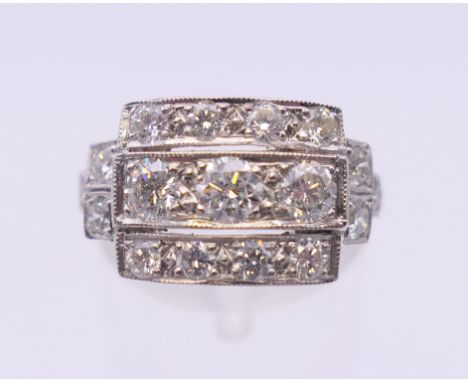 An Art Deco style platinum three row diamond ring. Ring size O/P. 5.2 grammes total weight.