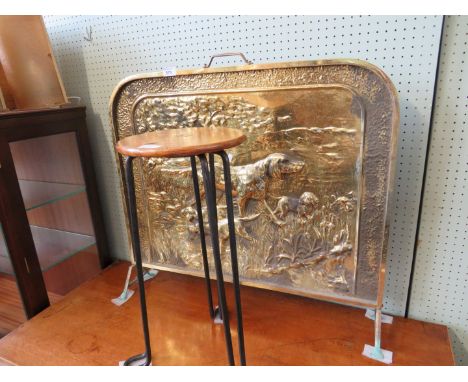 A vintage brass coloured fire screen embossed with hunting dogs in landscape 