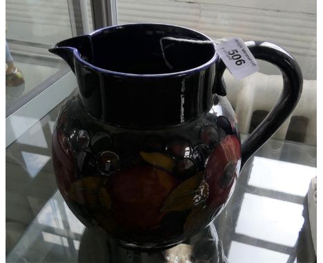 A large Walter Moorcroft pottery jug of bulbous form, decorated in the Pomegranate pattern on a blue ground, impressed factor