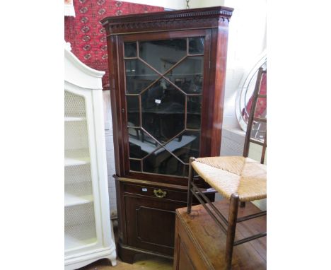 A George III mahogany floor standing corner cabinetFormed of two sections, the top section with dentil cornice and single ast