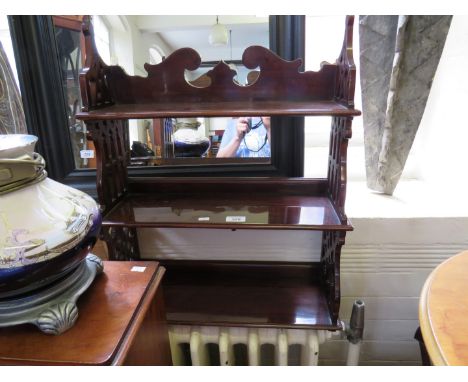 A reproduction mahogany Chippendale style hanging shelf unit