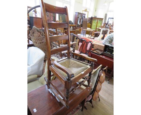 A rush seated ladder back rocking chair.