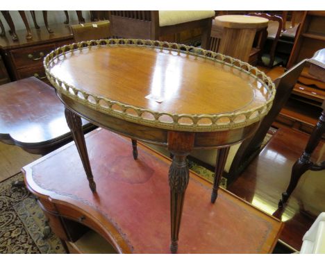 A small oval Edwardian mahogany occasional table with galleried metal surround