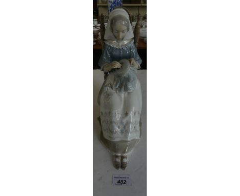 A Lladro figure of a seated young lady sewing. CONDITION REPORT: Finial at the back of one side of chair has been broken and 