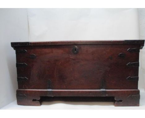An 18th century continental walnut chest with iron corners, strapwork and handles, having a hinged top and straight sides, on