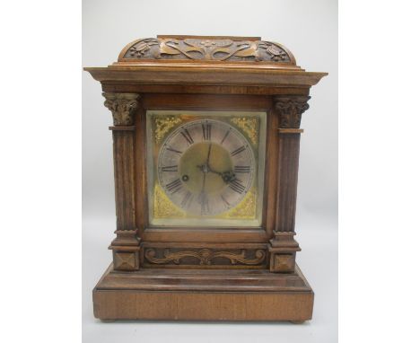 A late 19th/early 20th century oak cased mantle clock, having a carved case with a gilt dial, silvered chapter ring and gilt 