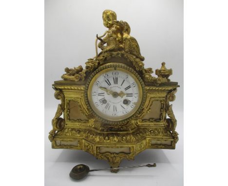 A mid/late 19th century French gilt metal mantle clock decorated with a cherub to the top with two birds, floral swag and ins