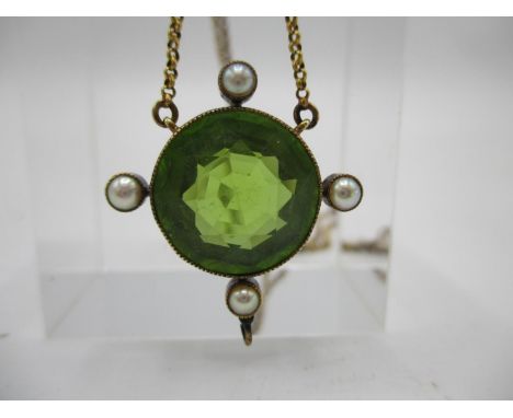 A late 19th/early 20th century pendant set with a round cut peridot and four seed pearls in a yellow metal frame, on a fine c