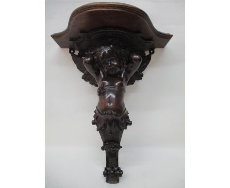 A late 19th century continental carved lime wood wall bracket with later additional top, over a cherub term, 18 1/2" 