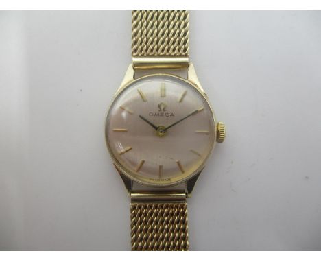 An Omega ladies 9ct gold manual wind wristwatch having a silvered dial with baton markers, the calibre 620 movement having 17