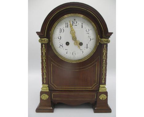 A late 19th century mahogany 8 day, arched top mantle clock having a white enamel dial with Arabic numerals and pierced gilt 