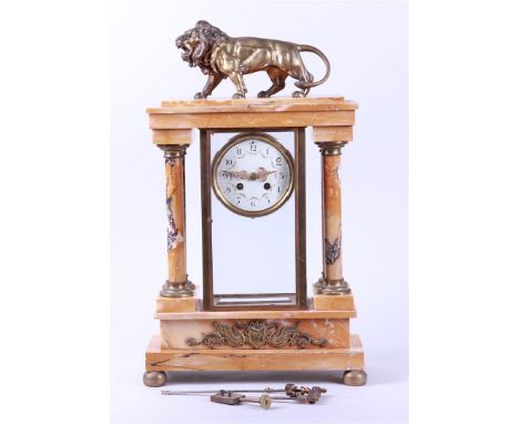 A marble column mantel clock with a roaring lion. The timepiece in a case with cut windows. ca. 1880.50 x 29 x 12 cm. 