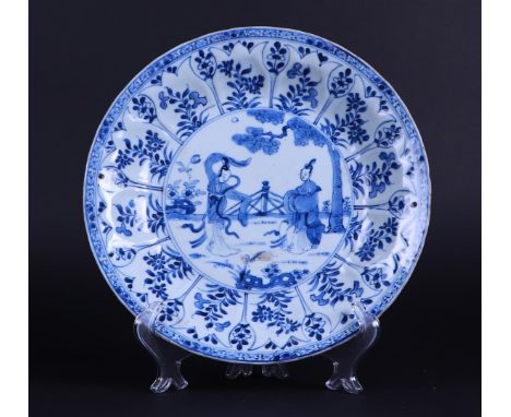 A porcelain dish with two dancing figures in a landscape with a fence decor, with a petal-shaped outside with floral decor. C