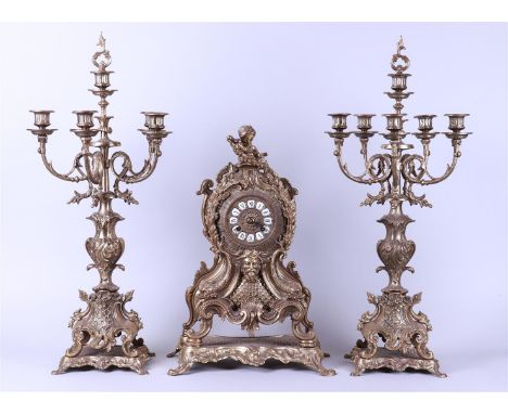 A large cast brass clock set consisting of two 5-armed candlesticks and a mantel clock with putto. France ca. 1890.H.: 72 cm.
