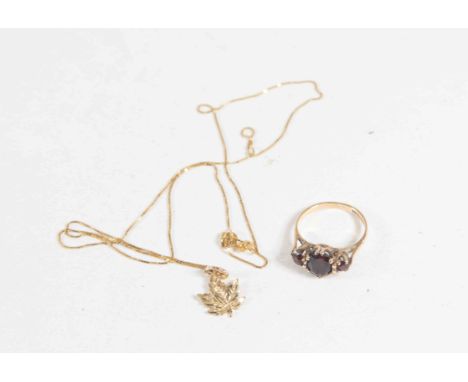 A 9 carat Gold maple leaf pendant together with a garnet 9 carat Gold ring
