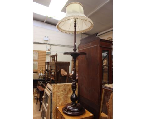 A 20th Century mahogany pedestal standard lamp, raised on a turned column and having a circular base
