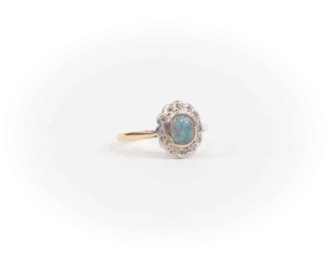An 18ct gold opal and diamond dress ring, set to the centre with a black oval opal, approx 6mm x 5mm, with a diamond set surr