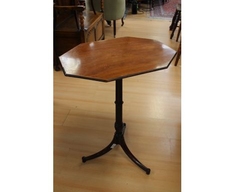 A George III mahogany tripod table, oblong octagonal top, raised on a turned column, sabre legs