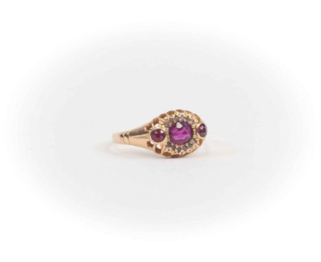 A Victorian ruby and diamond cluster 18ct yellow gold ring, oval ruby set to the centre with diamond border,  two round cuts 