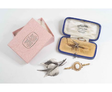 A silver leaf broochAn Edwardian 9 carat gold and seed pearl swallow brooch, and a 9 carat gold and opal brooch (3)