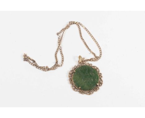 A jade carved disc, 9ct gold pendant and chain