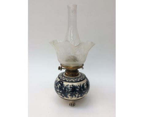 Continental ceramic oil lamp in original matching stand, having lion paw feet, fluted glass shade having floral etched decora