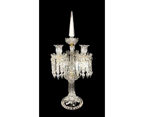 A three light crystal epergne or centrepiece candelabrum having a faceted spire finial over a flowerhead drip pan and faceted