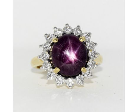 An 18ct yellow gold star ruby & diamond cluster ring. Ruby of 7.4cts and 80 points of diamond