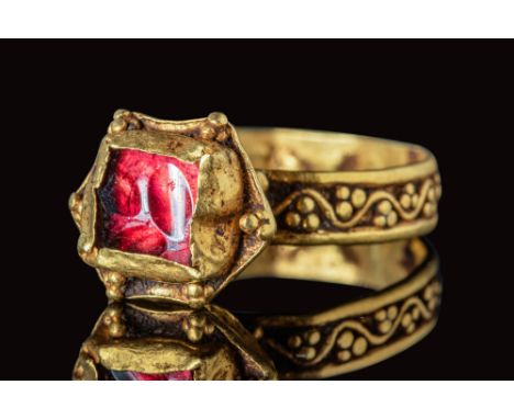 Ca. AD 500 - 600 .A beautiful Byzantine gold ring with a red garnet. The ring has a round hoop with a flat section, decorated