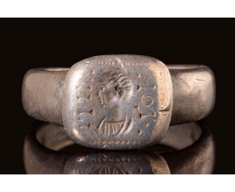 Ca. AD 400 - 700. A Byzantine silver ring with a round hoop connected to a square bezel which is engraved with a profile of a