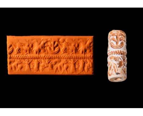 Ca. 2600 - 2400 BC. A Levantine white marble cylinder seal. The engraved surface is divided in two registers by a banded leaf