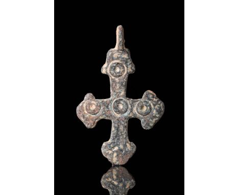 Ca. AD 900 - 1100.A cast-bronze crucifix pendant with five engraved circles with indents at the top and at the centre of the 