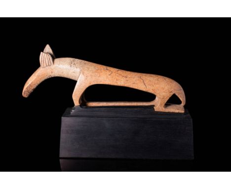 Ca. 1 millenium BC.A bone figurine of an animal, standing on four legs, on a square base. The body of the figurine is extreme