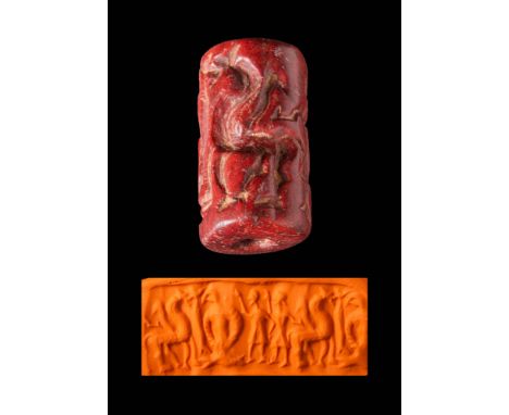 Ca. 1500 - 500 BC.A Central Asiatic red Stone Cylinder seal. The design shows two humans in kilts raising one hand to a group